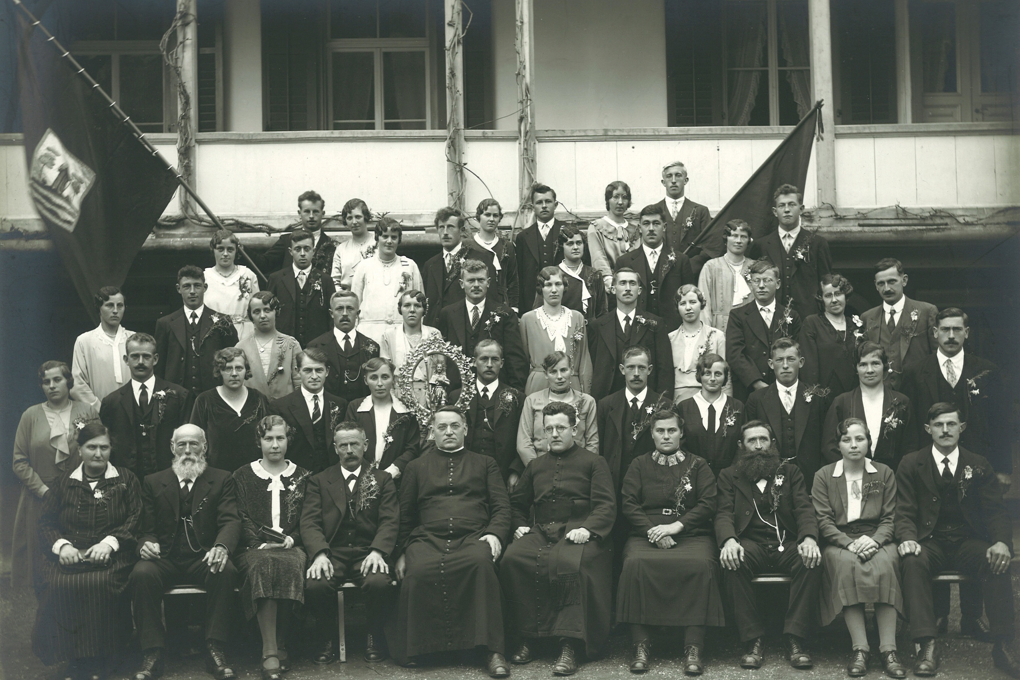 Beamten der Älplerbruderschaft Wolfenschiessen mit Begleiterinnen, vorne in der Mitte die Geistlichkeit, dahinter die St. Wendelinsstatue, 1931 © Staatsarchiv NW