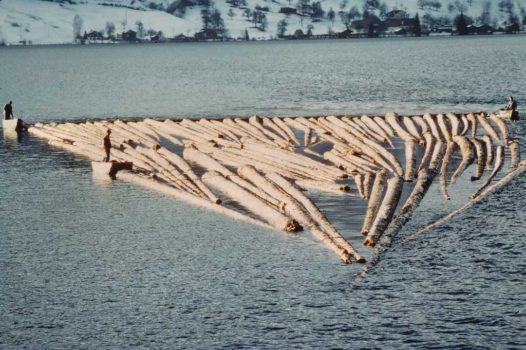 Flössen mit den antreibenden Motorbooten am Heck und einem Boot zur Fahrstabilitätskontrolle, um 1980 © Familie Anton Henggeler-Frank, Morgarten