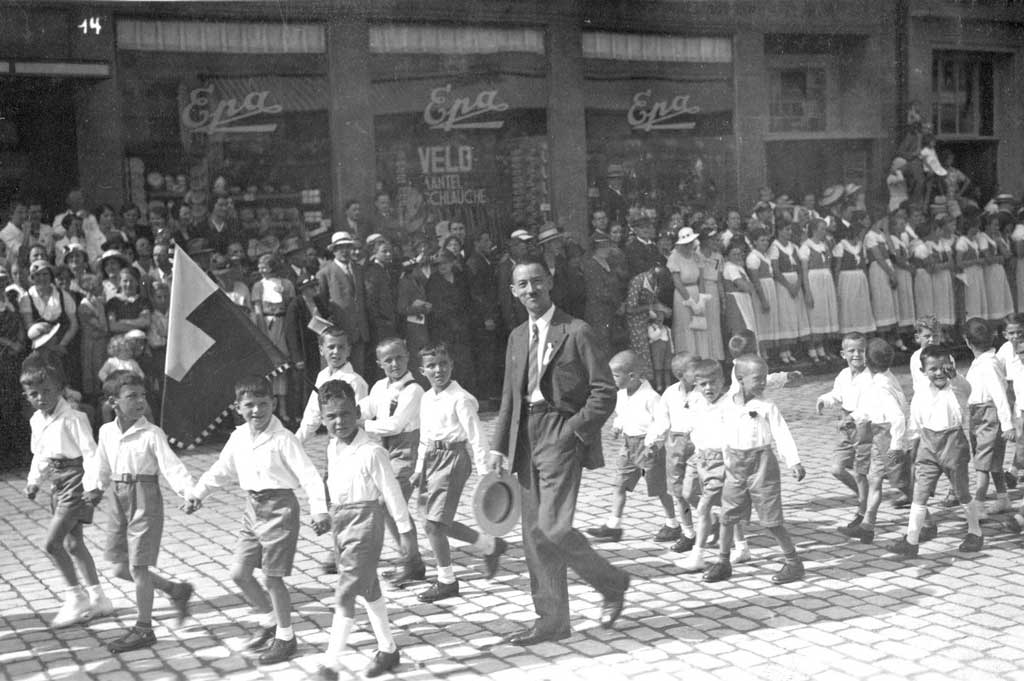 Festzug der Unterschulen am Bohl vor zahlreichem Publikum und Trachtengruppe, 1932 © Louis Baumgartner, St.Gallen/Stadtarchiv St.Gallen