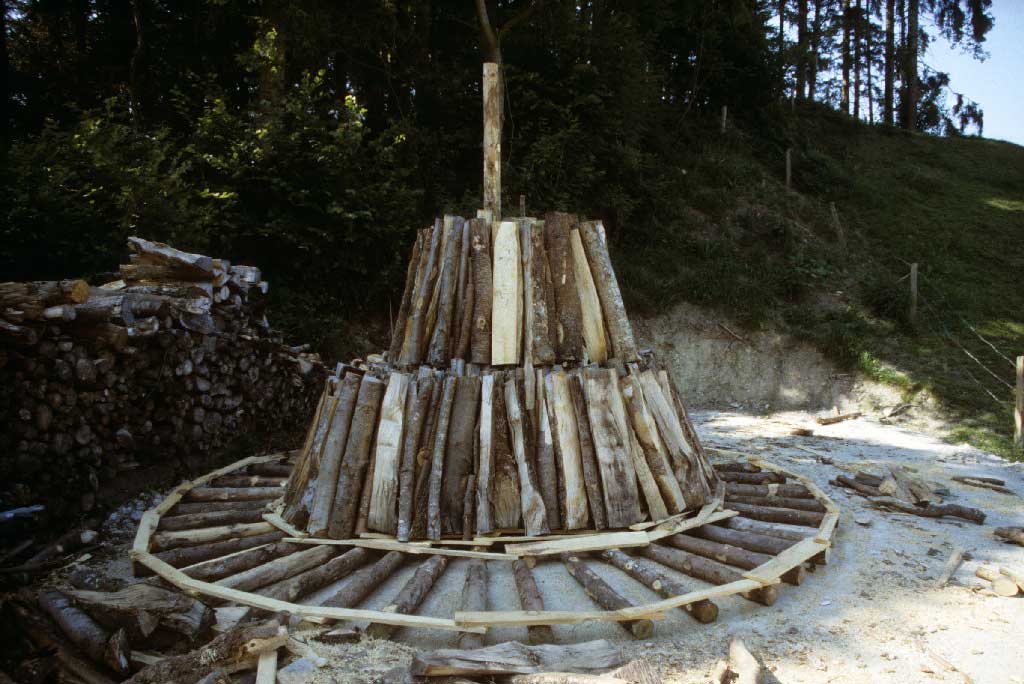 Der Bodenrost ist das Fundament des Meilers, in dessen Mitte der eingesteckte «Füllibaum» emporragt, zwischen 1980 und 2005 © Paul Duss, Romoos