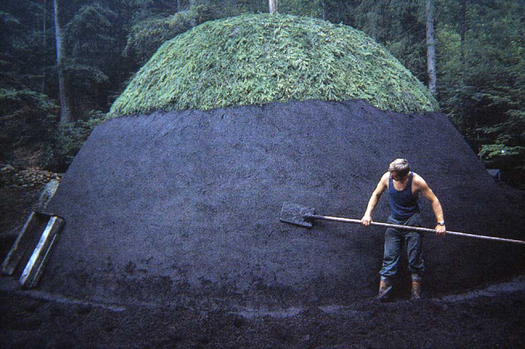 Ein Köhler trägt die «Löschi» auf den Meiler auf, im oberen Teil ist die Reisigabdeckung sichtbar, zwischen 1980 und 2005 © Paul Duss, Romoos
