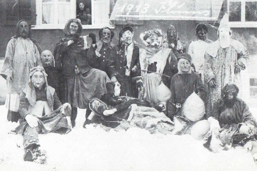 Flumser Strassenfasnacht mit Butzi-Gruppe in gebrauchten «Huttlen», 1913