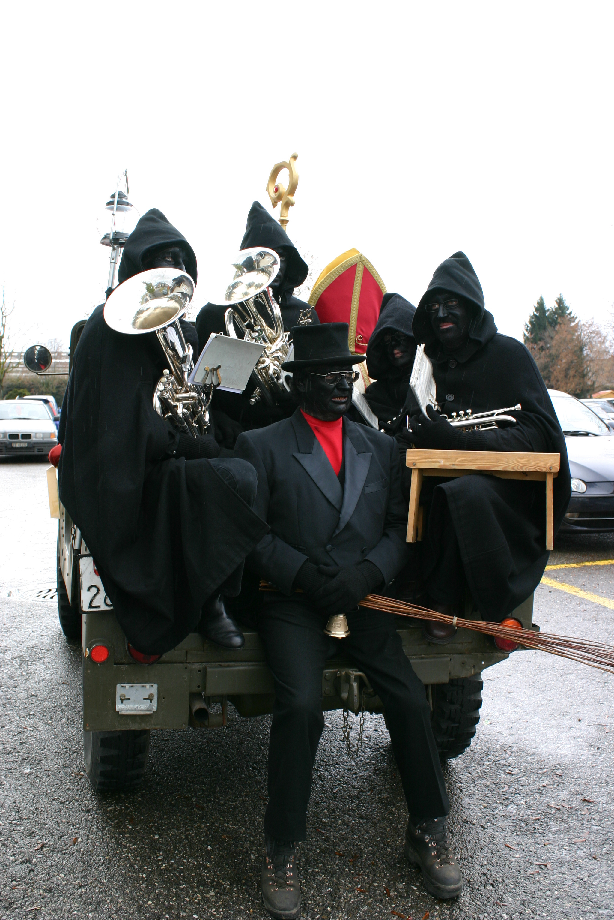Sankt Nikolaus im Jeep in den Strassen von Bulle, begleitet von den schwarzen «Flons-Flons», den Schmutzlis; er geht in jedes Haus und bringt den Kindern Geschenke. © Compagnie de Saint Nicolas, Tretaux de Chalamala, Bulle