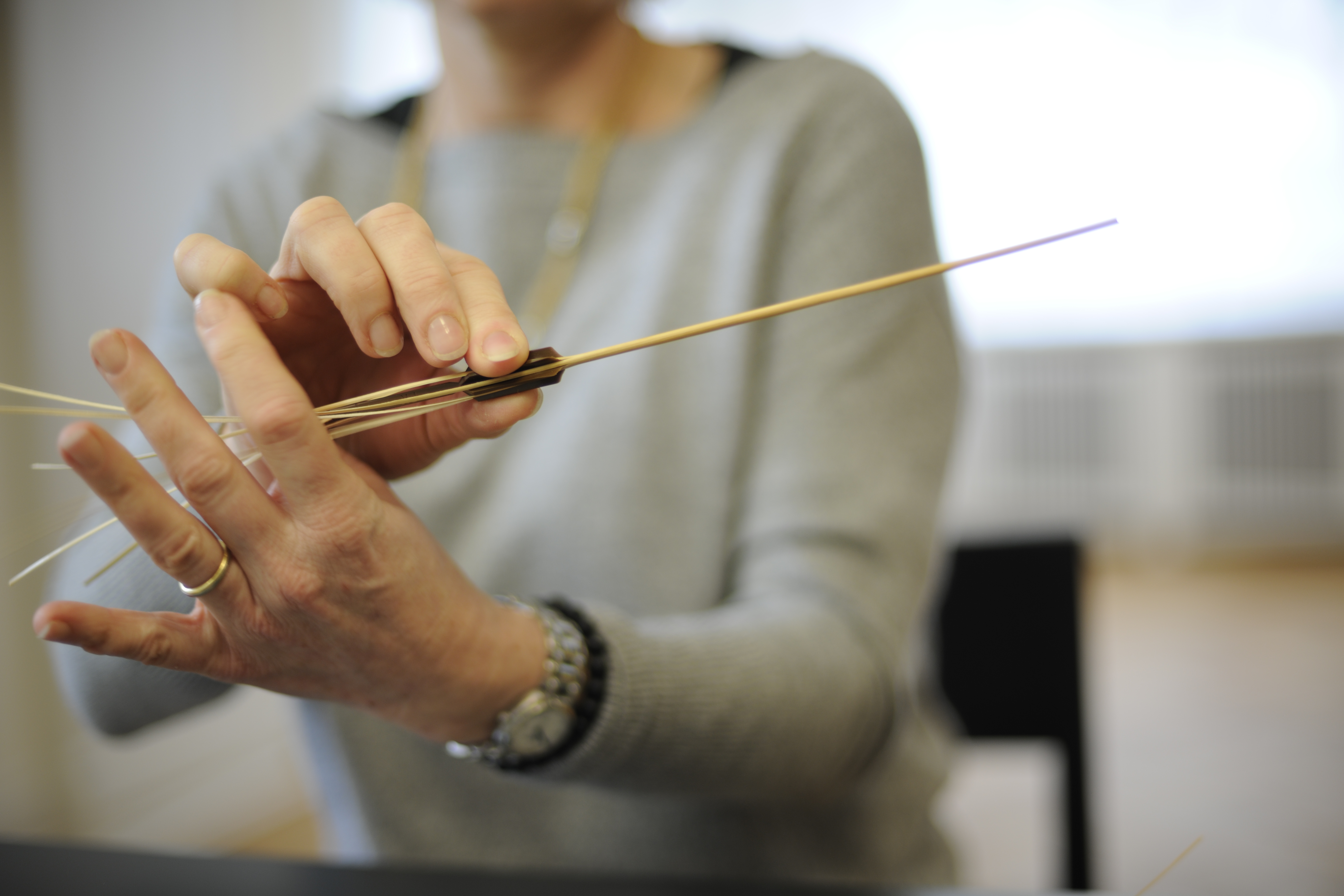Ein Strohhalm wird mit einem «Spalterli» in mehrere Streifen gespalten © Schweizer Strohmuseum, 2024