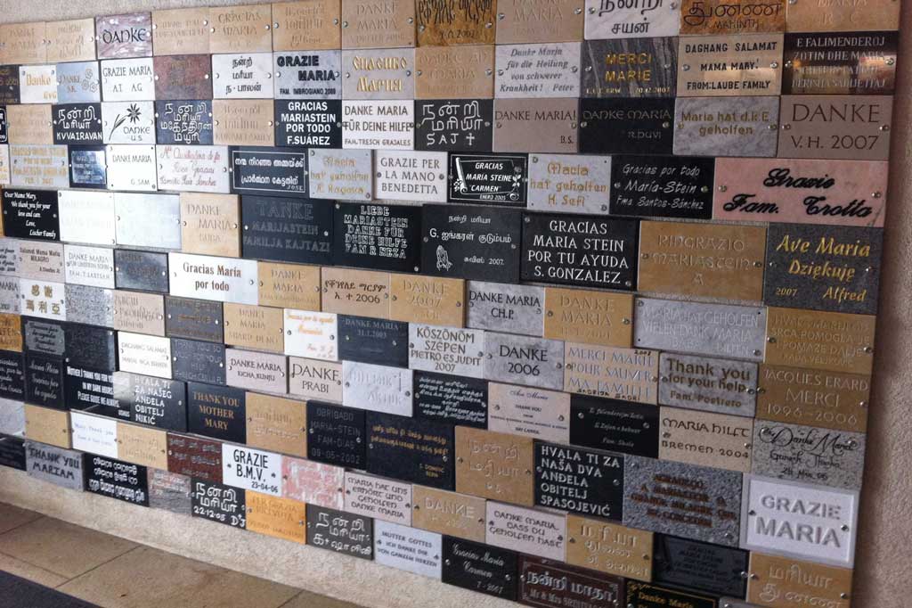 Different languages and alphabets on the ex-voto panels on the abbey walls © Kira von Rickenbach, 2011