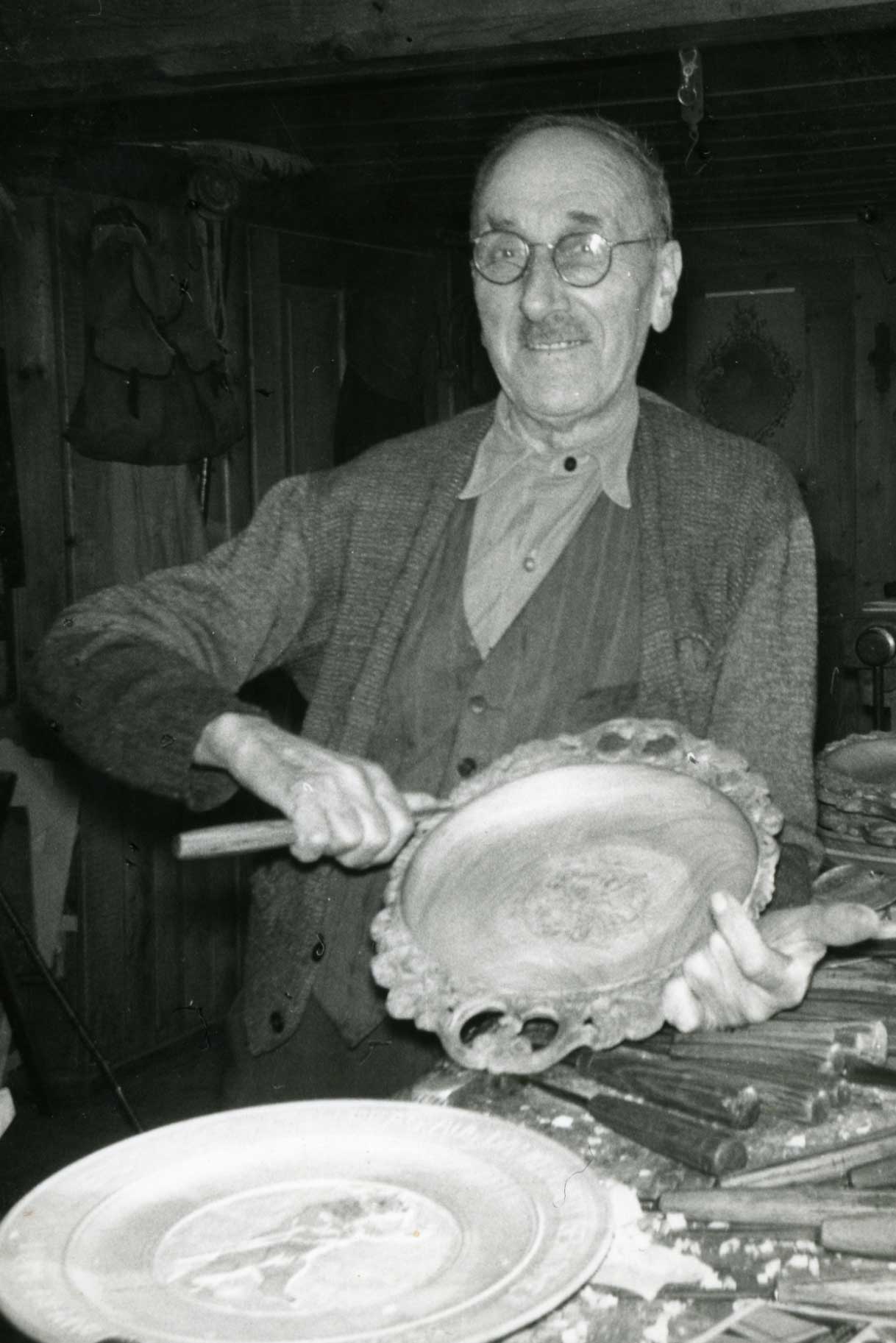 Woodcarver with his work, Schwanden near Brienz, ca 1960 © Peter Ernst, Brienz/Stiftung Holzbildhauerei