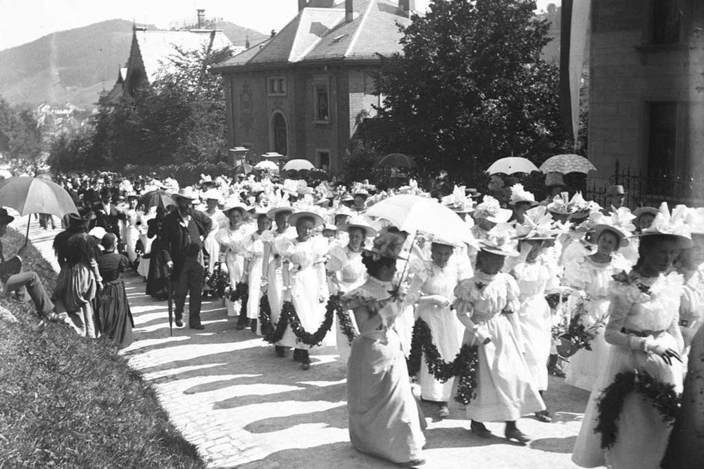 Elèves en robes longues blanches avec des guirlandes en chemin pour le champ de fête, probablement 1898 © Eventuell Schalch & Ebinger, St.Gallen/Stadtarchiv St.Gallen