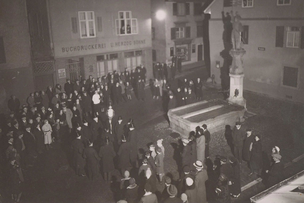 Les membres de la confrérie chantent à la fontaine Albrecht, l’ancienne fontaine de l‘hôpital © Sebastiani-Bruderschaft, Rheinfelden, 1930