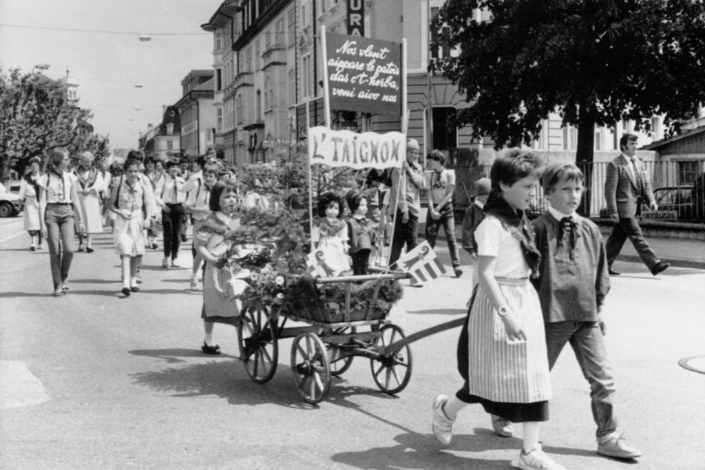 Delémont, 1990 : Fête cantonale des patoisants, les enfants des Franches-Montagnes défilent © Archives cantonales jurassiennes (ArCJ)