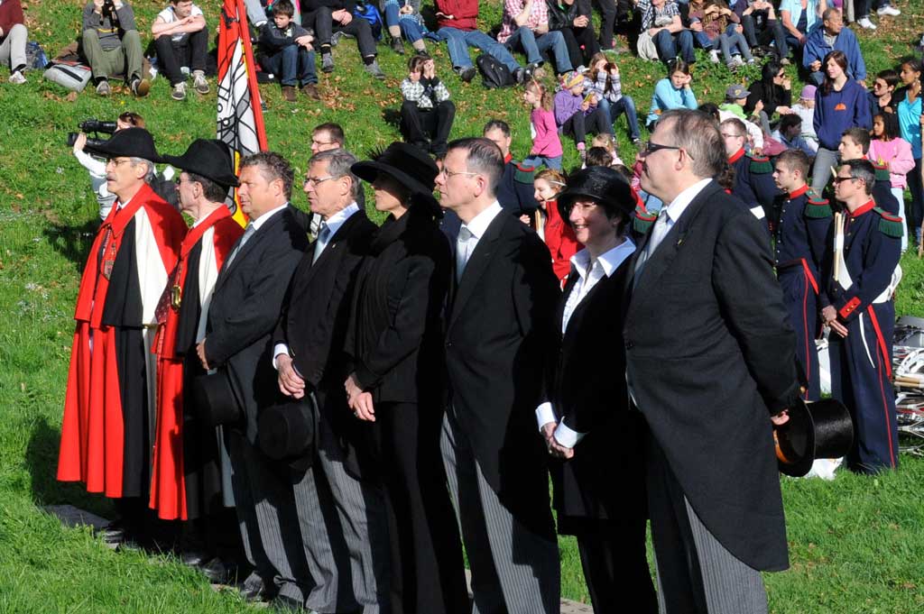 Les membres du gouvernement en queue-de-pie et haut de forme ou chapeau écoutent la fanfare de Näfels © Heinrich Speich, 2011