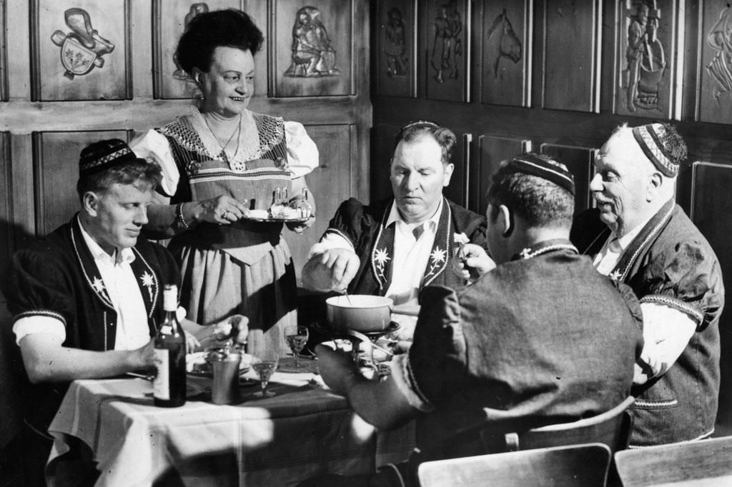 Presentazione folcloristica della fondue al caffè «Le Tivoli» a Châtel-Saint-Denis © Glasson/Musee gruerien, Bulle, 1964