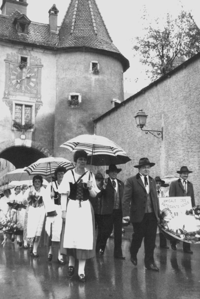 Porrentruy, 1987: l'«Amicale des patoisants vadais» sfila sotto la Porte de France, a Porrentruy © Archives cantonales jurassiennes (ArCJ)