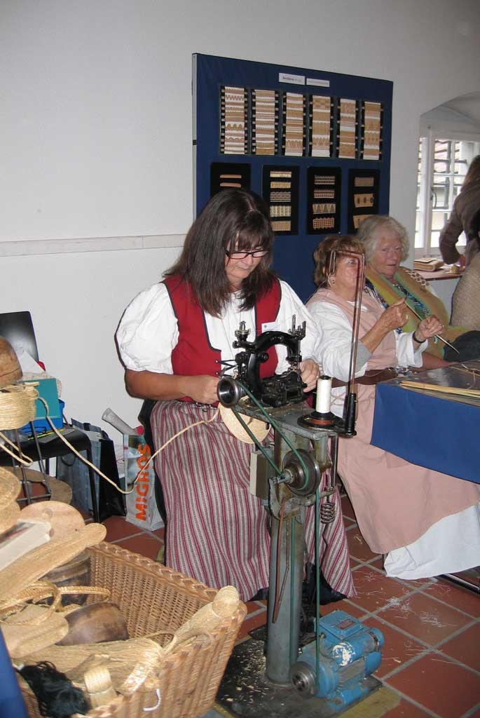 Al mercato nel centro storico di Bremgarten, una tessitrice di paglia mostra una fase della produzione di un cappello di paglia © Karin Janz, 2011
