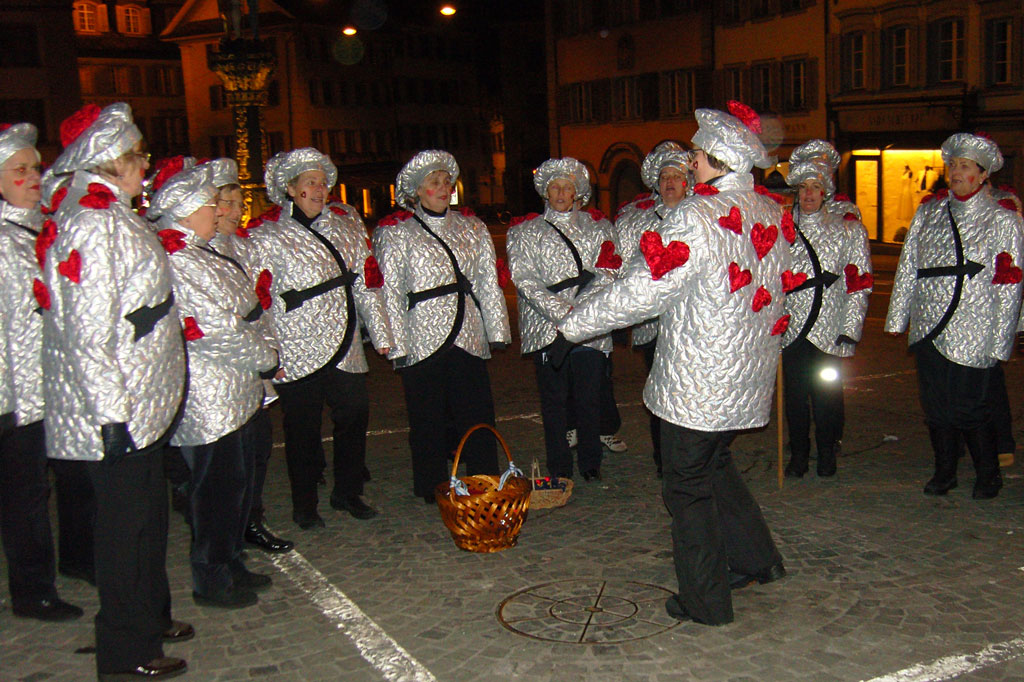 Chantond sin il Kolinplatz retschaiva il chor da la gruppa da costums il chanaster cun las strizlas, 2010 © Ernst Moos, Zug