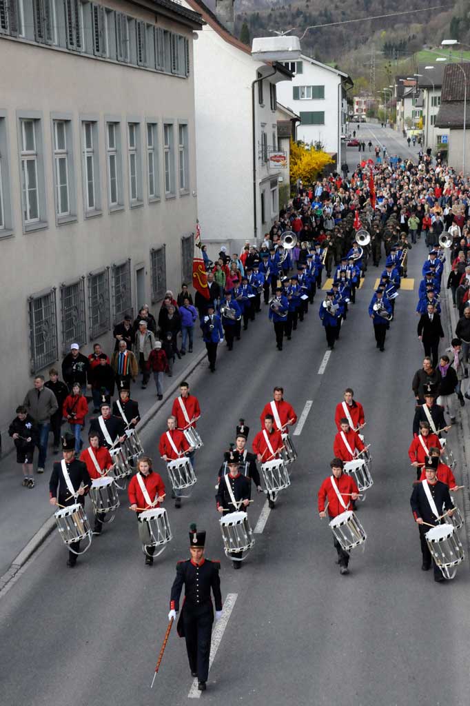 Il cortegi va tras Netstal: tamburs, Musica d'armonia, furmaziun militara d'onur © Heinrich Speich, 2011